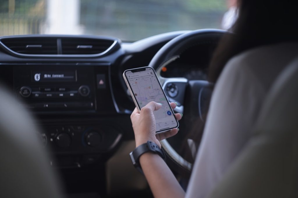 A woman holding a cell phone while driving a car A woman holding a cell phone while driving a car