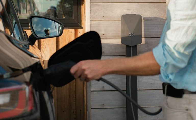 a man pumping gas into his car at a gas station a man pumping gas into his car at a gas station